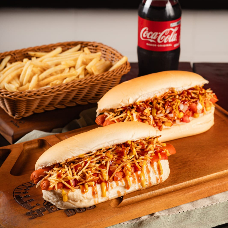 Delicie-se com nossa oferta irressistivel - o combo ( tradicional gourmet). Ele vem com 2 lanches gourmet, onde cada um é feito com pão cuidadosamente prensado na chapa e recheado com duas salsichas ( PERDIGÃO). Para realçar o sabor, acrescentamos maionese, uma fresca salada de tomate e cebola preparado no mesmo dia, milho e batata palha crocante. Para finalizar, uma generosa porção de catchup e mostarda. Além disso, este combo inclui duas porções de batata fritas pequenas sequinhas e saborosas, além de uma refrescante coca cola original de 600 ml. Aproveite nossa promoção de combos com até 20% de desconto e experimente.