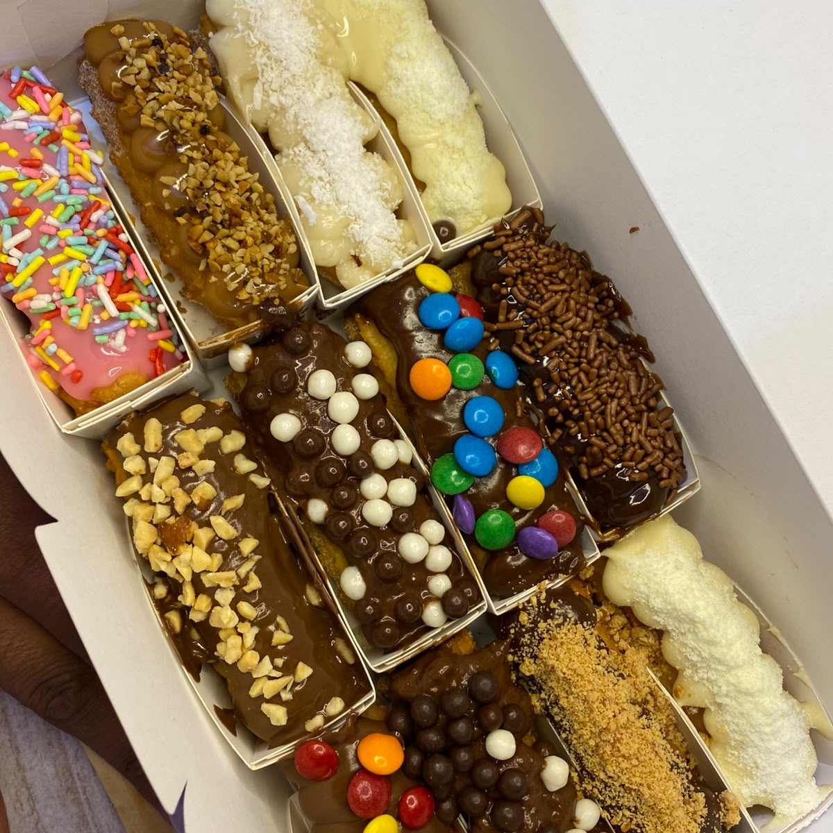 12 mini churros de massa fresca, artesanal, feita todos os dias, bem fritinho e crocante, envolvido em açúcar e canela, com recheios cremosos e granulados a sua preferencia. (os granulados são enviados na ordem da comanda, caso tenha uma preferencia especifica, nos mande uma mensagem pelo chat no ato do pedido:)