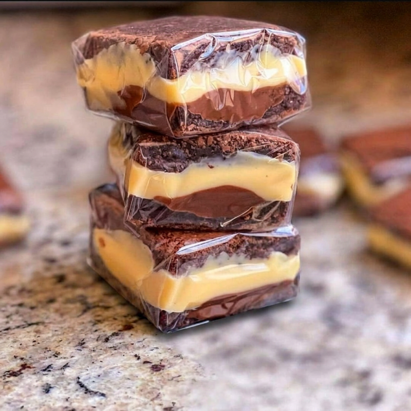 O brownie recheado com Ninho e Nutella é uma sobremesa irresistível que combina a intensidade do chocolate com a suavidade do leite em pó e a riqueza do creme de avelã. O brownie possui uma textura densa e úmida com casquinha crocante, recheado com uma camada cremosa de leite Ninho e um toque de creme de avelã, aprox 85g.