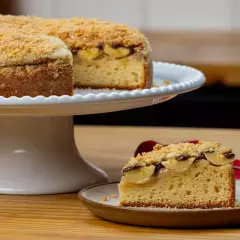 Massa macia com camadas de banana polvilhadas com açúcar e canela, gotas de chocolate ao leite e finalização com farofa crocante. Imagem meramente ilustrativa.Bolo pequeno serve até 8 fatias