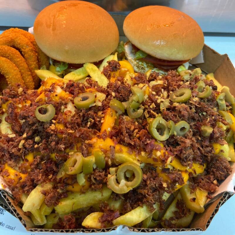 Combo para casal com 2 X- Tudo, batata cheddar-bacon, calabresa, anéis de cebola, azeitona e alho frito.