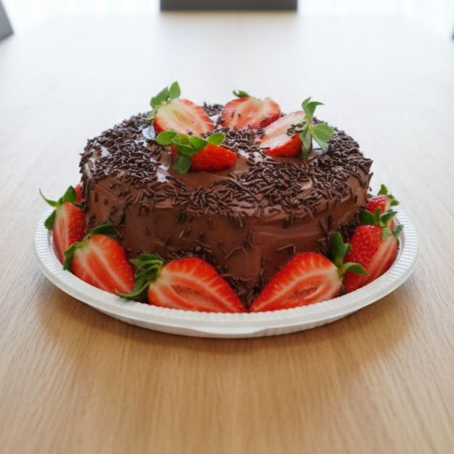 Massa de chocolate fofinha e molhadinha com uma cobertura de creme Brigadeiro, morangos picados no cone do bolo, decorado com morangos frescos e granulados