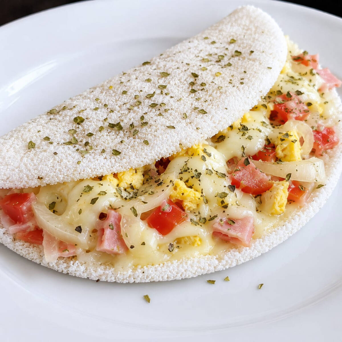 Uma verdadeira explosão de sabores! Tapioca preparada na hora, recheada com presunto, mussarela, ovo, cebola, tomate e orégano, combinando ingredientes selecionados que garantem um sabor marcante e irresistível. Uma opção completa, saborosa e cheia de personalidade!