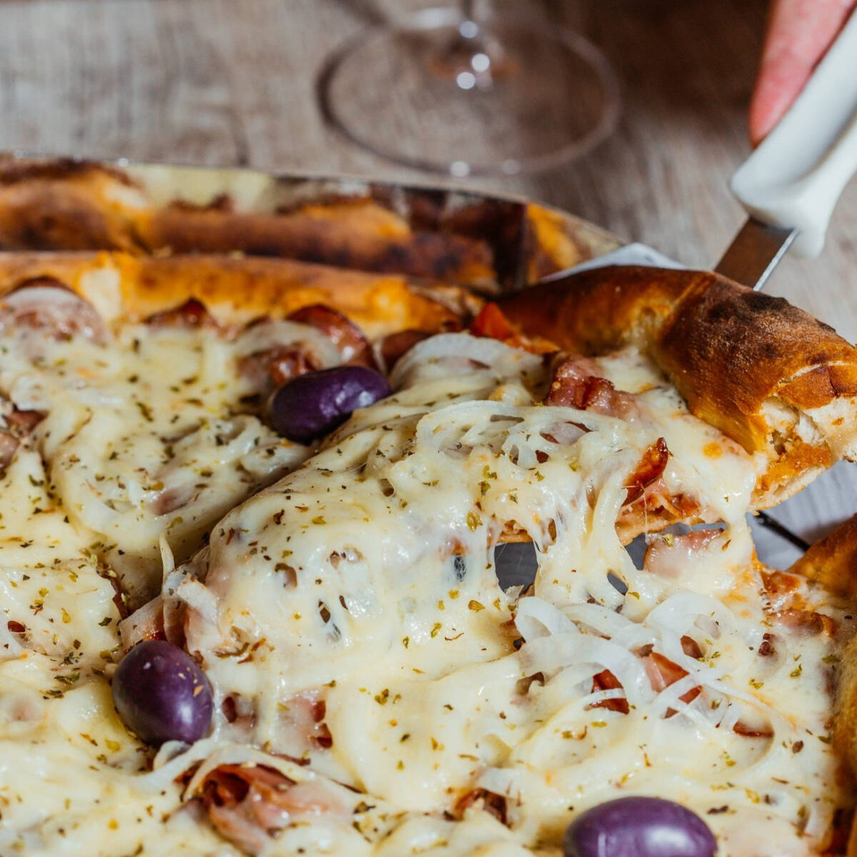 Molho de tomates frescos, linguiça calabresa fatiada, cebola, coberta com mozzarella e azeitonas pretas