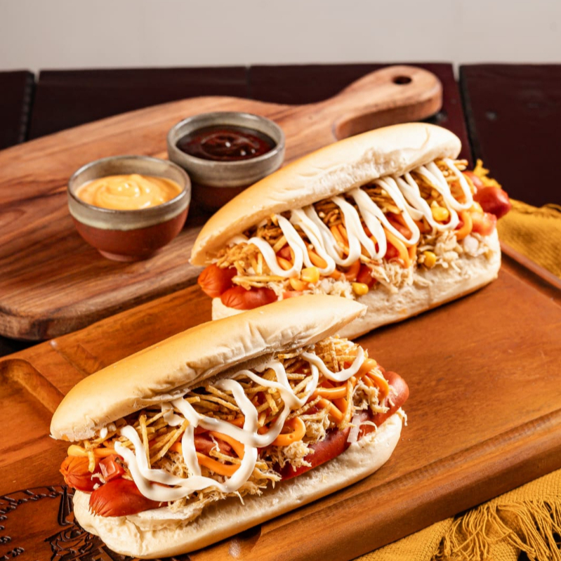 2 x Dog Frango prensado na chapa, 2 salsichas ( PERDIGÃO), Frango desfiado cheddar cremoso, maionese, batata palha e para finalizar cream chesse que da um toque especial.