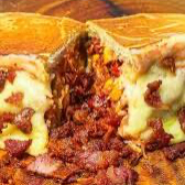 Acompanha 2 salsichas, purê de batata, cheddar, catupiry, milho, vinagrete ( cebola e tomate), maionese, ketchup, mussarela e bacon e batata palha