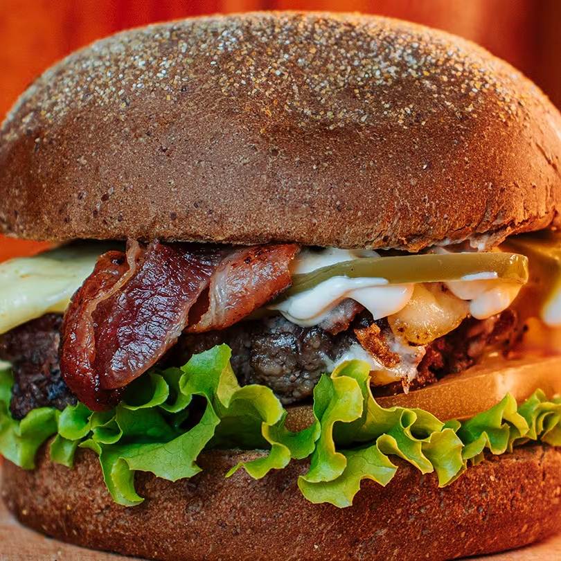 Black Pepper Burger: Hambúrguer Artesanal de 150g, Queijo Coalho, Bacon Crocante, Pimenta Biquinho, Alface Crocante, Tomate, Cebola Roxa e Molho de Alho no Pão Australiano. Uma Explosão de Sabores Intensos e Picantes!