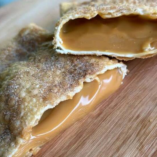 Recheado com doce de leite, polvilhado com açúcar e canela por fora.