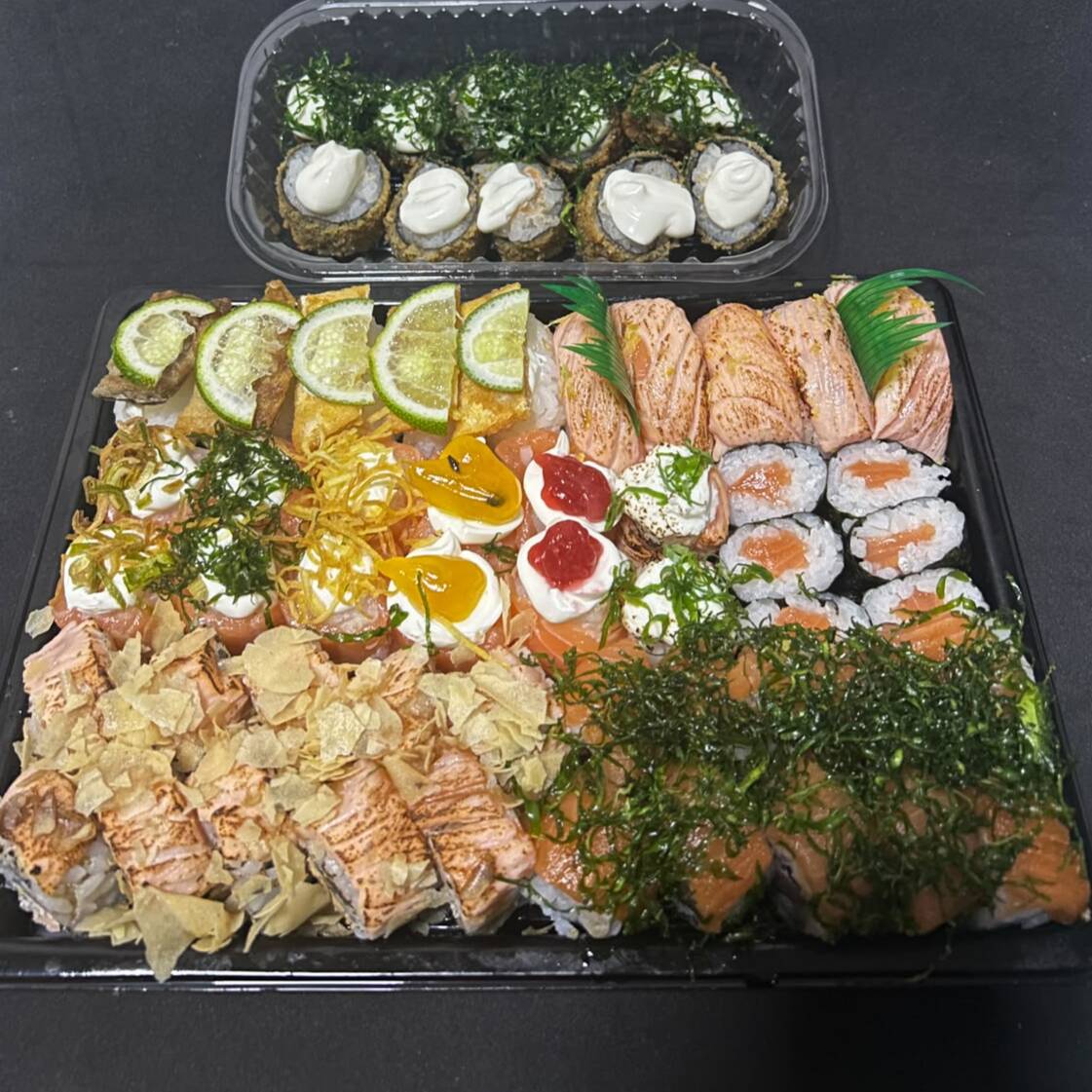 Composto por:
10 Uramakis Especiais Frescos com salmão e cream cheese, finalizados com molho tarê e couve crocante.
10 Uramakis Especiais Flambados com salmão grelhado e cream cheese, finalizados com molho tarê e couve crocante.
5 Niguiris Trufados, delicadamente finalizados com raspas de limão siciliano.
5 Niguiris Skin com o equilíbrio perfeito entre sabor e crocância.
12 Joys Variados preparados com ingredientes selecionados.
6 Hossomakis de Salmão.
5 Mini Hots de Kani com toque especial de couve crocante.
5 Hots Tradicionais dourados e crocantes.