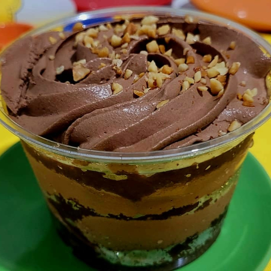 O Bombom Ferrero na versão copo! Feito com pão-de-ló de chocolate, recheio generoso de creme de avelã, cobertura de ganache de chocolate premium, decorado com castanhas de caju moídas dando aquele toque final! Peso: 250 gramas. Serve 1 pessoa. - Importante: atendendo às melhores práticas de confeitaria, nosso produto é mantido semicongelado para maior frescor e qualidade.