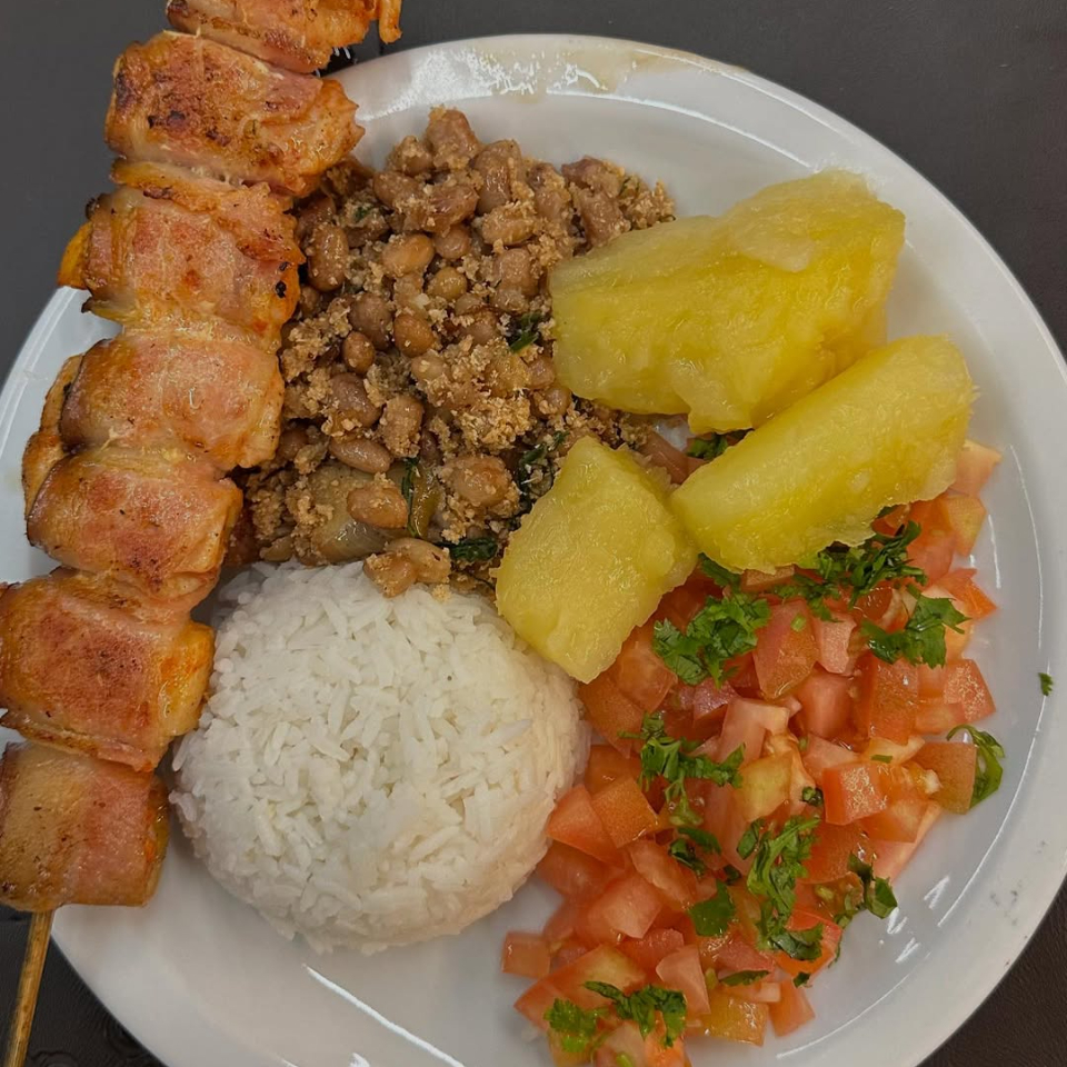 Arroz branco soltinho, feijão tropeiro bem recheado, vinagrete fresco, mandioca cozida e um espeto de frango com bacon assado na brasa.