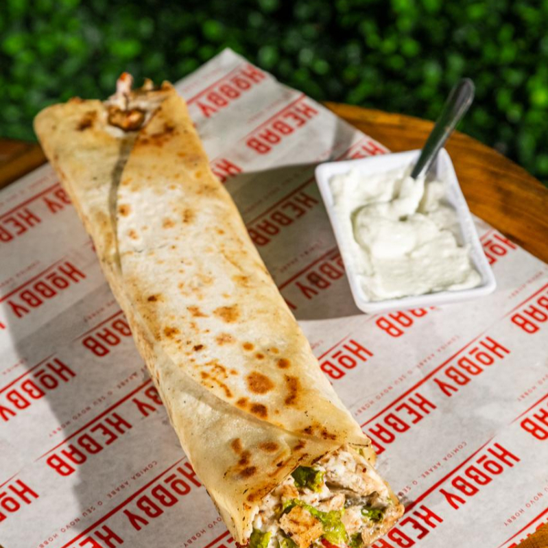 Pão sírio de 25cm recheado com frango em cubos delicadamente temperado, alface fresco, tomate maduro e cebola temperada. Acompanha o molho de alho caseiro.