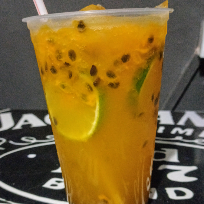 Deliciosa caipirinha feita com polpa de maracujá, cachaça, xarope de açúcar e gelo.