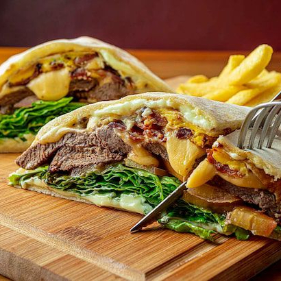 Pão sírio, carne de fraldinha 150g preparada na grelha, queijo mussarela, presunto, dois ovos, alface americana, tomate, cebola caramelizada e molho opcional. Obs: Acompanha batatinha frita.