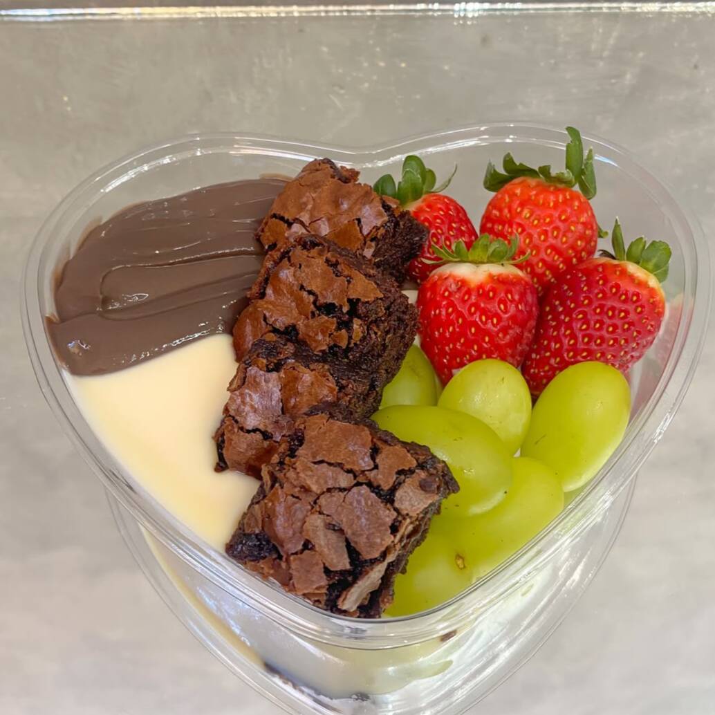 NÃO É ENVIADO QUENTE. Quadradinhos do nosso brownie artesanal acompanhados de brigadeiro cremoso ao leite, brigadeiro cremoso de Ninho, morangos frescos e uvas selecionadas. A combinação perfeita entre chocolate e frutas para uma experiência ainda mais especial. Peso aproximado: 350g.