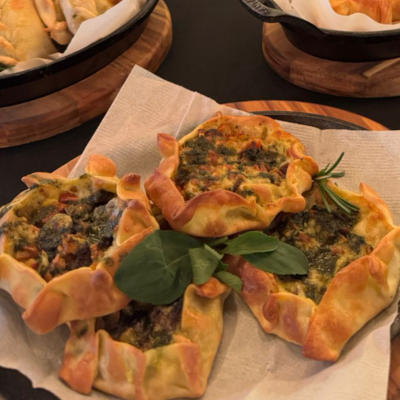 Empanada recheada de tomate, muçarela, azeitonas pretas e finalizada com uma emulsão caseira de manjericão que faz toda a diferença.