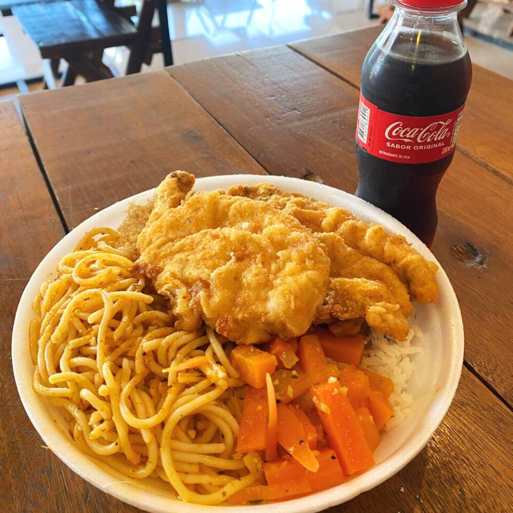 Uma marmita caseira bem servida com frango à milanesa crocante, acompanhada de arroz soltinho, feijão branco, macarrão, refogado e farofa. Tudo preparado na hora, com aquele sabor de comida de verdade. 🥤 Acompanha Coca-Cola 200ml gelada. 🥗 Salada opcional – se desejar, escreva na descrição do pedido que enviamos junto. Perfeita para um almoço rápido, saboroso e bem servido.
