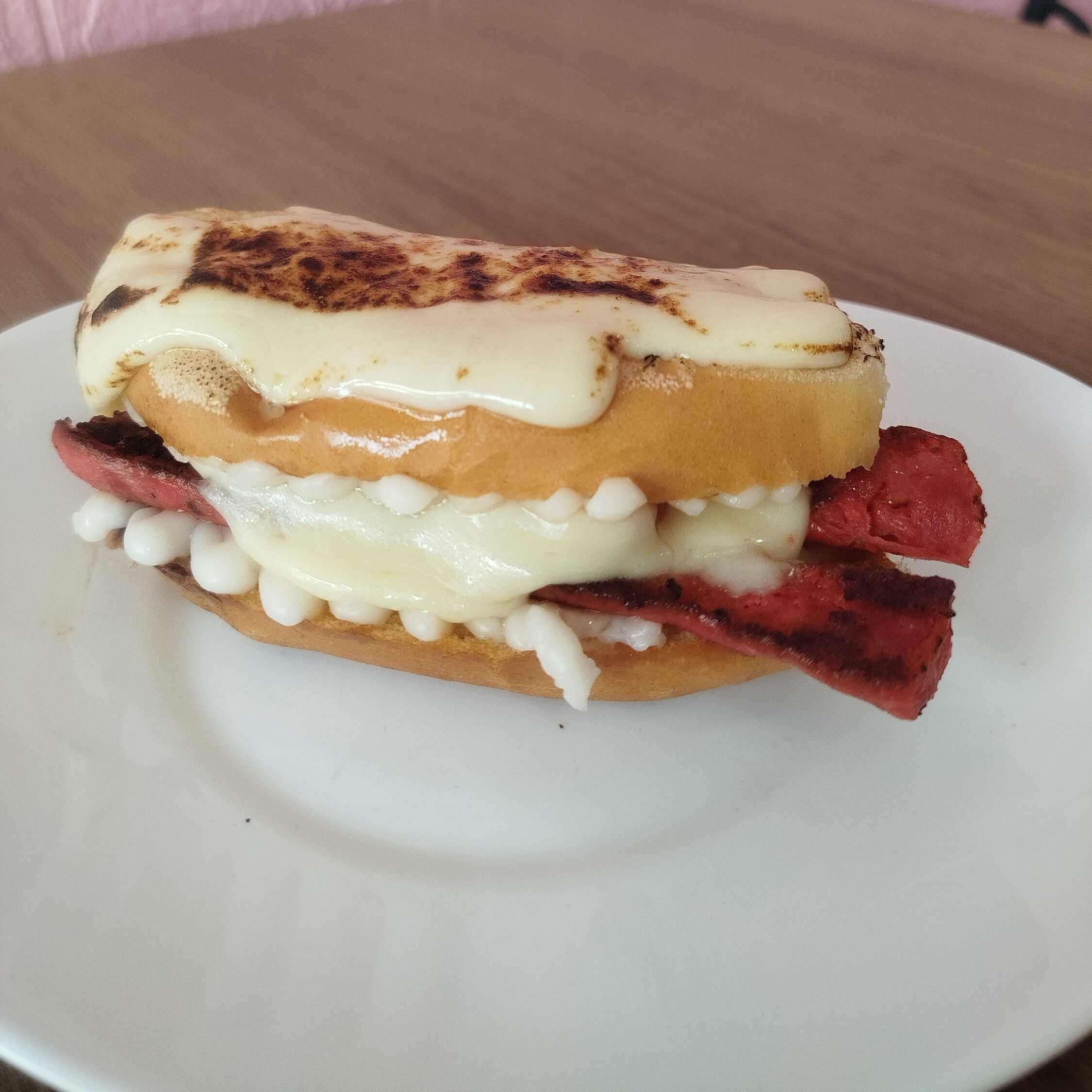 Pão francês recheado com requeijão, muçarela e linguiça mineira, finalizado com muçarela