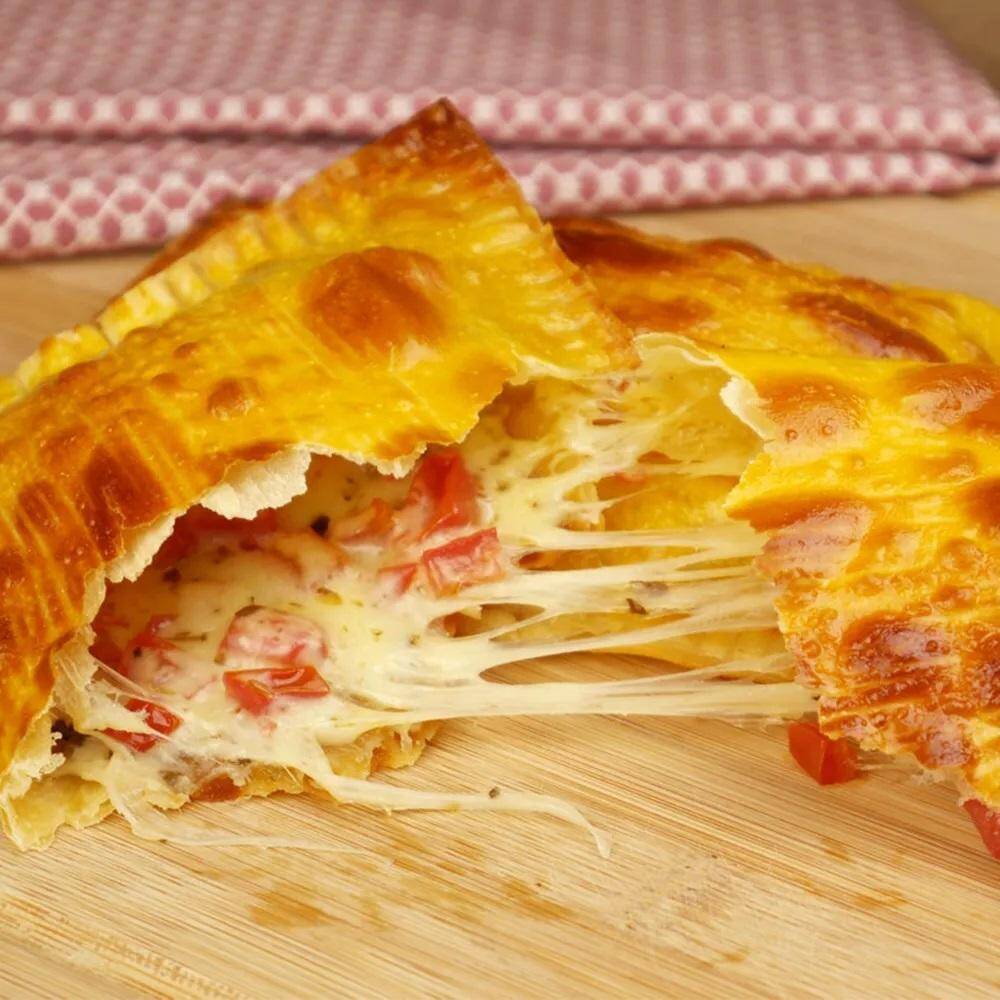 Pastel de Pizza, preparado com massa crocante e recheio saboroso de queijo derretido, presunto, tomate e orégano. Uma combinação clássica e irresistível, perfeita para quem ama o sabor de pizza em um pastel.