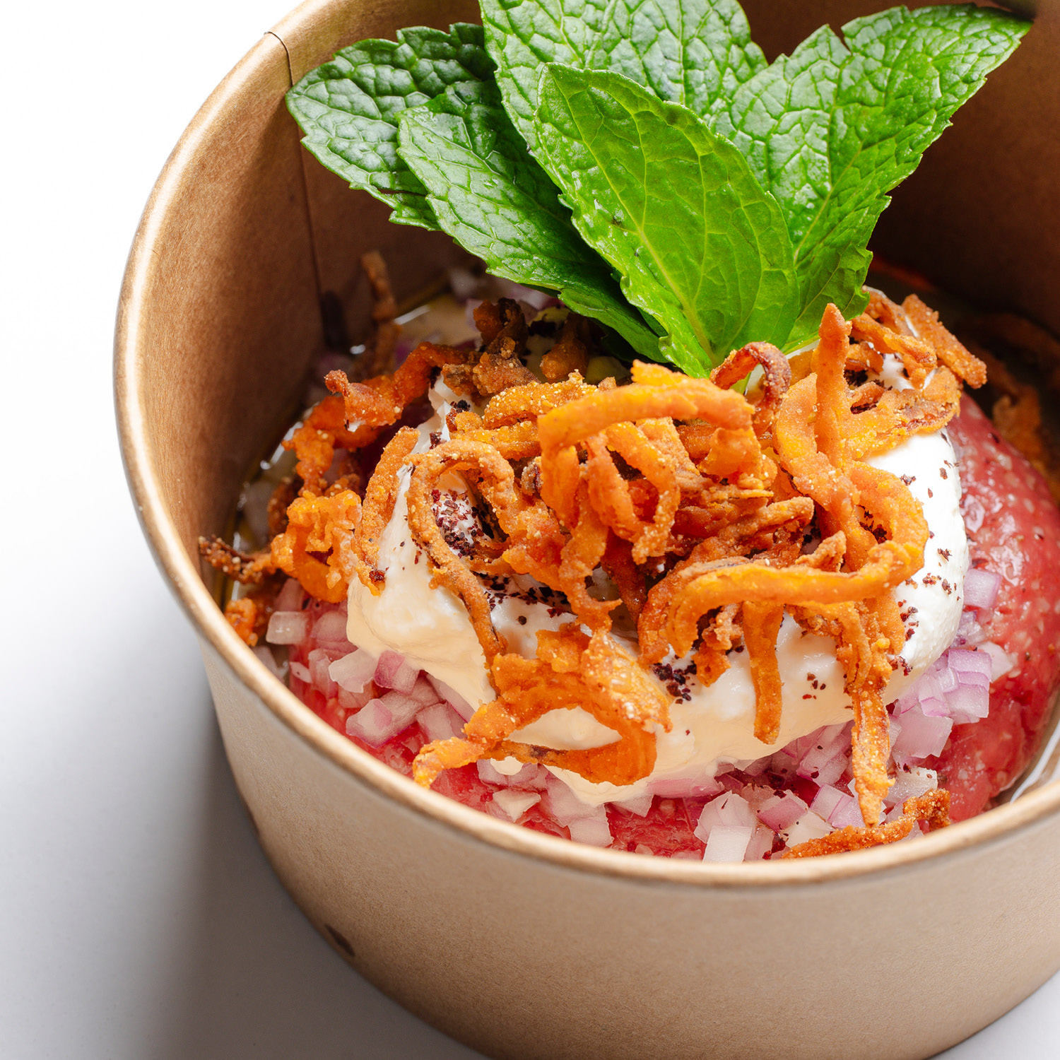 KIBE CRU COM COALHADA SECA DA CASA, ROMÃ, HORTELÃ, SUMAC E CEBOLA CRISPY. (PORÇÃO INDIVIDUAL) CONTÉM LACTOSE. CONTÉM GLÚTEN.