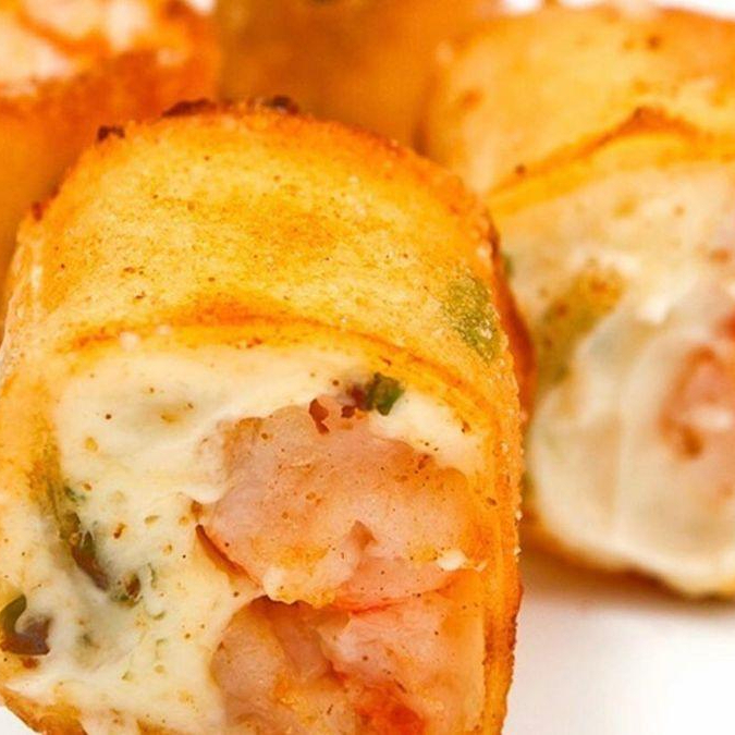 Sushi enrolado na massa harumaki, recheado com salmão, camarão, kani, cream cheese e cebolinha