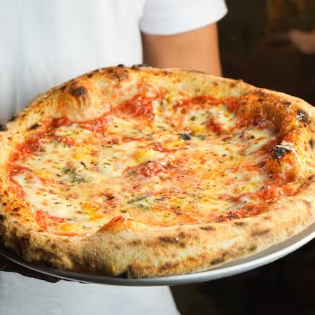 Massa de fermentação natural, molho de tomate italiano,mozzarella fiordilatte, provolone da Mantiqueira e gorgonzola, finalizado com grana padanoe orégano Obs: por padrão, a pizza é enviada inteira (não fatiada) para garantir uma melhor conservação e mantê-la quente por mais tempo (além de facilitar caso você queira reaquecê-la no forno ao recebê-la). Se preferir que enviemos a pizza cortada em fatias, favor especificar na observação do pedido ;)