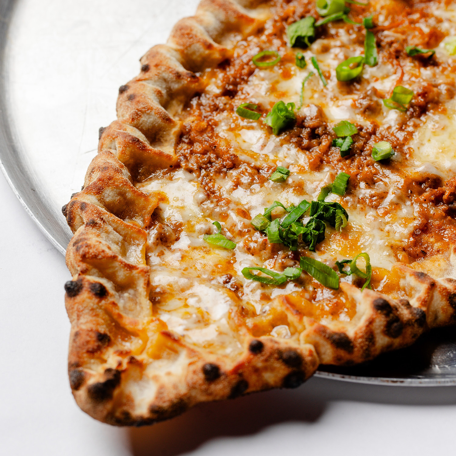 ESFIHA TURCA EM FORMATO DE BARCA, COM MOLHO DE TOMATE, CARNE DE CORDEIRO MOÍDA COM ESPECIARIAS, MUSSARELA E CEBOLINHA. CONTÉM GLÚTEN. CONTÉM LACTOSE.