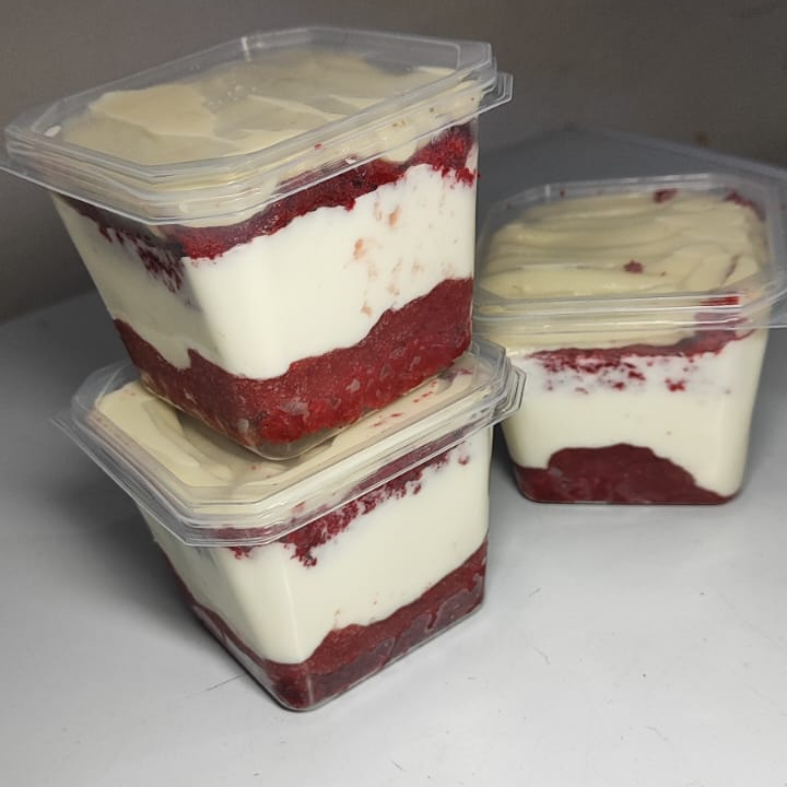 Massa tradicional do red velvet, recheio de cream cheese com uma leve camada de geleia de morango, finalizado com uma camada de ninho