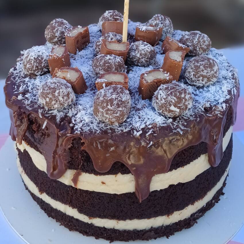 Bolo delicioso de chocolate com recheio de coco. Finalizado com brigadeiro gourmet pedaço de bombom prestígio e finalizado tbm com a caldinha de chocolate