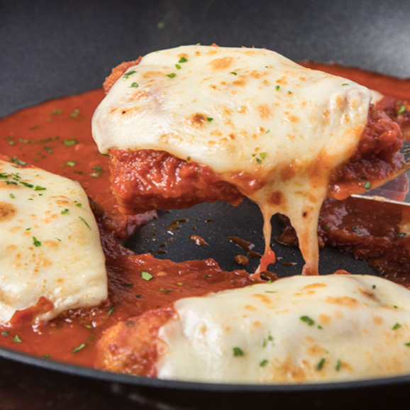 Será a melhor Parmegiana que você irá comer em sua vida, com molho de tomate artesanal e uma camada de queijo derretido. Acompanhado de salada de legumes, arroz, feijão e farofa. Foto meramente ilustrativa. Não é possível modificar o prato.