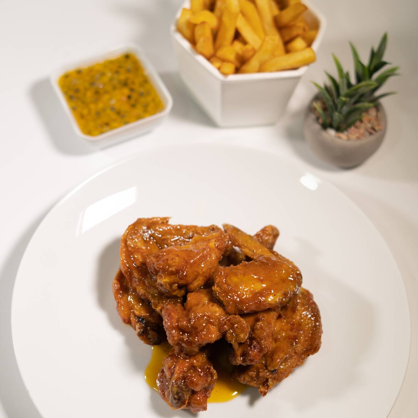 Alitas Maracuyá Picante y Papas a la Francesa.