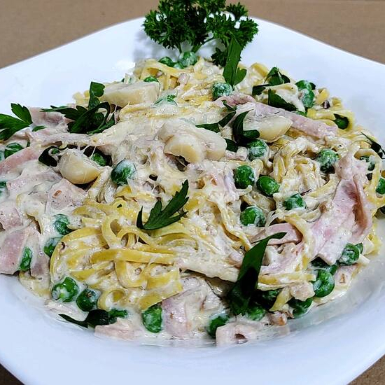 Massa artesanal ao molho de creme de leite com presunto, ervilhas frescas e champignon