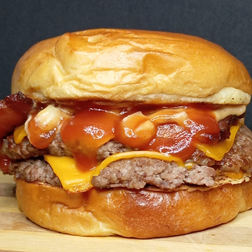 Duplo cheddar compão brioche macio da maná selado na manteiga com hamburguer de 100g ,(sem alface) , bacon crocante , queijo cheddar derretido e molho especial da casa entrega gratis