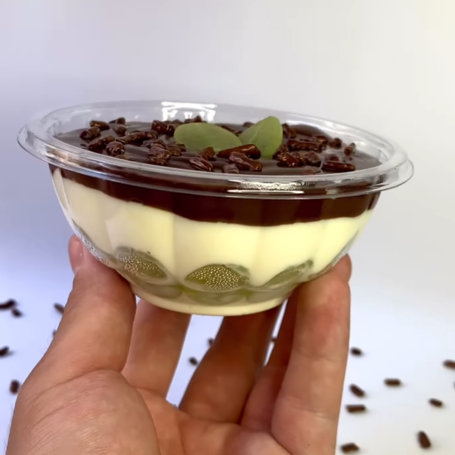 Bombom aberto , com creme de Ninho , uvas verdes sem semente e ganache de chocolate.