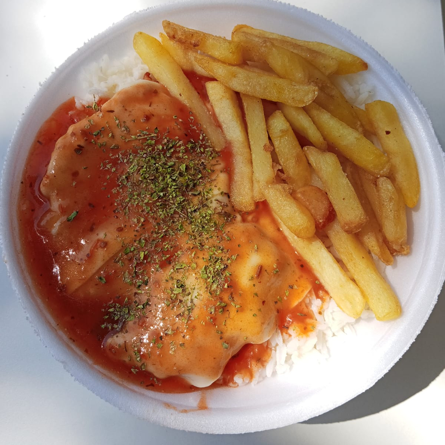Parmegiana de Frango – filé de frango empanado no ponto certo, coberto com molho de tomate artesanal e uma generosa camada de queijo derretido. Acompanha arroz branco soltinho e batata frita crocante, formando a combinação perfeita.