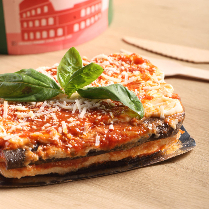 Camadas de berinjela grelhada, molho bechamel e pomodoro, queijo derretido e manjericão fresco.