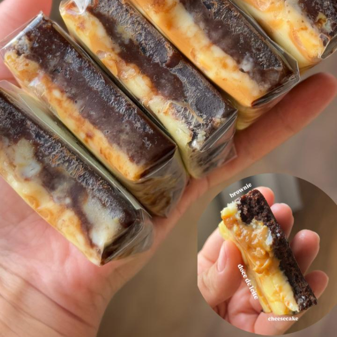 Delicioso brownie (6x6 cm), com base densa de chocolate, recheio aveludado de cheesecake e finalização com doce de leite cremoso e artesanal. Servido gelado, oferece um contraste de sabores e texturas que encanta até os paladares mais clássicos.