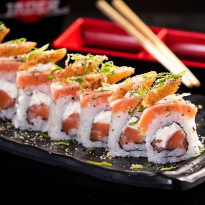 Uramaki de salmão com cream cheese, coberto por lâmina de salmão maçaricada, finalizado com camarão empanado e cebolinho.