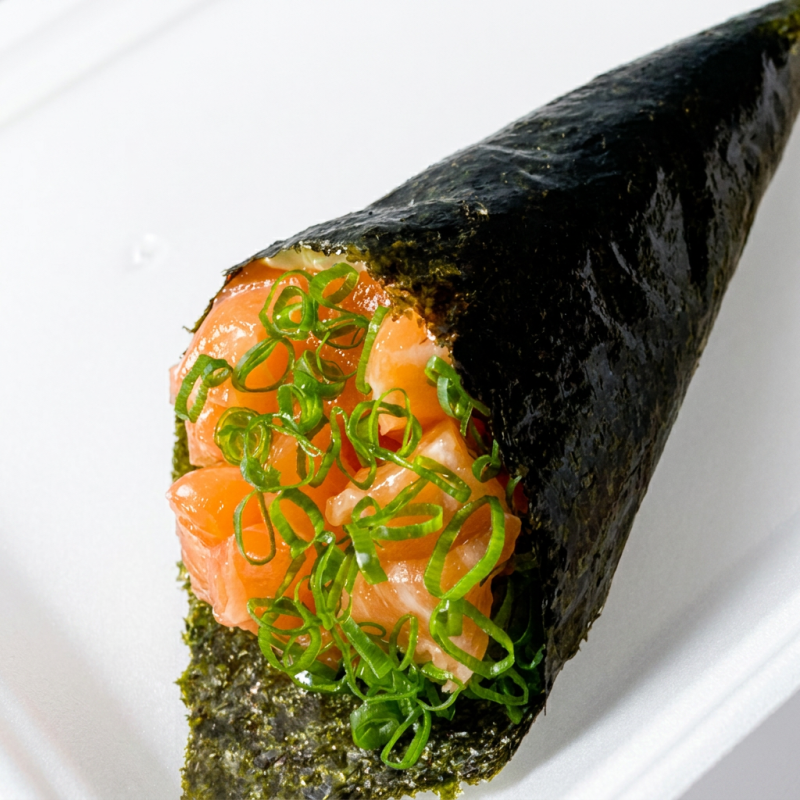 Cone de alga com arroz, salmão, cebolinha e gergelim. Acompanha duas porções de shoyu premium e um hashi. Experimente essa combinação deliciosa e autêntica.