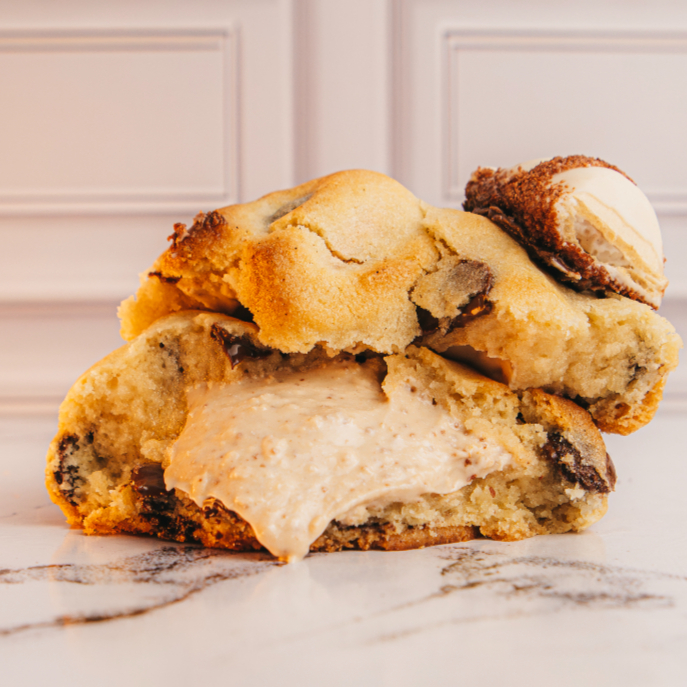 Nosso cookie de Kinder Bueno é feito com massa tradicional e gotas de chocolate nobre meio amargo. Recheado com creme de Kinder Bueno artesanal.