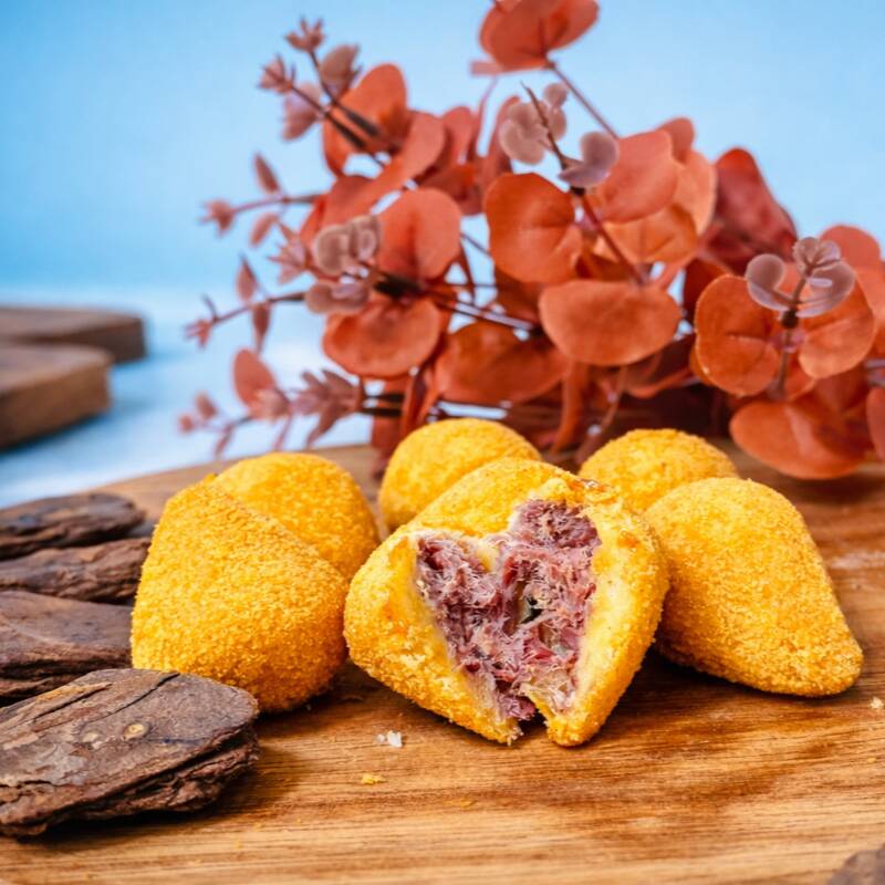 Coxinha artesanal feita com massa macia e dourada, recheada com carne seca desfiada, bem temperada e extremamente cremosa, garantindo sabor marcante a cada mordida. Empanada na medida certa e frita até ficar crocante por fora e irresistível por dentro.