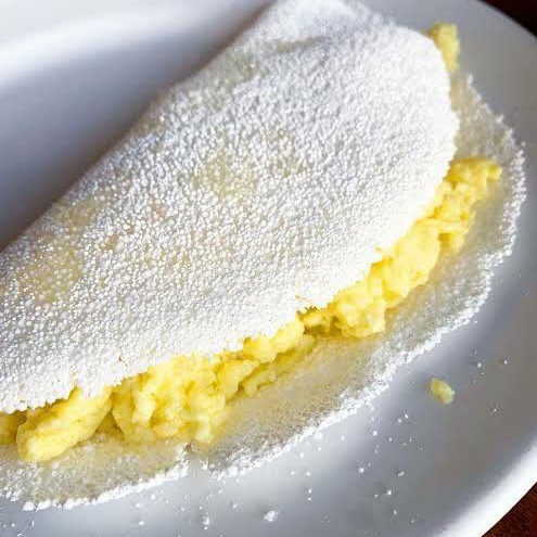 A 'Tapioca Ovo Mexido e Mussarela' é um prato deliciosamente reconfortante que promete agradar ao paladar. A base é feita com uma massa de tapioca levemente crocante por fora e macia por dentro. Ovos mexidos com a cremosidade da mussarela.