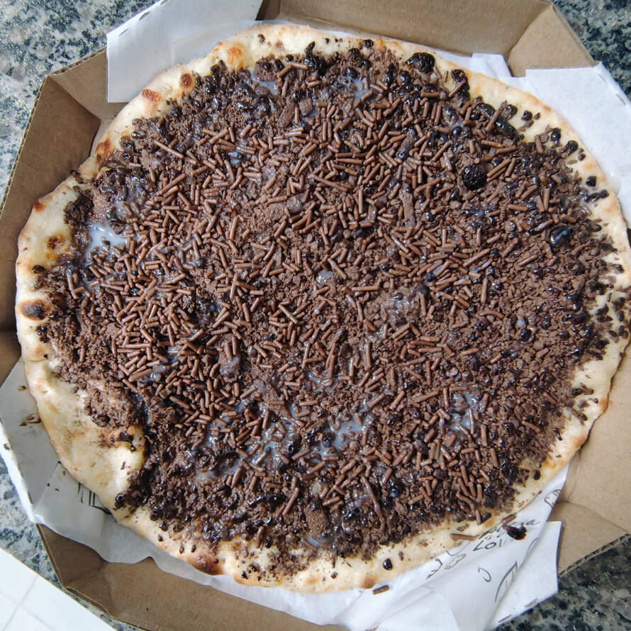 Queijo muçarela com raspas de chocolate ao leite, granulado e fios de leite condensado.