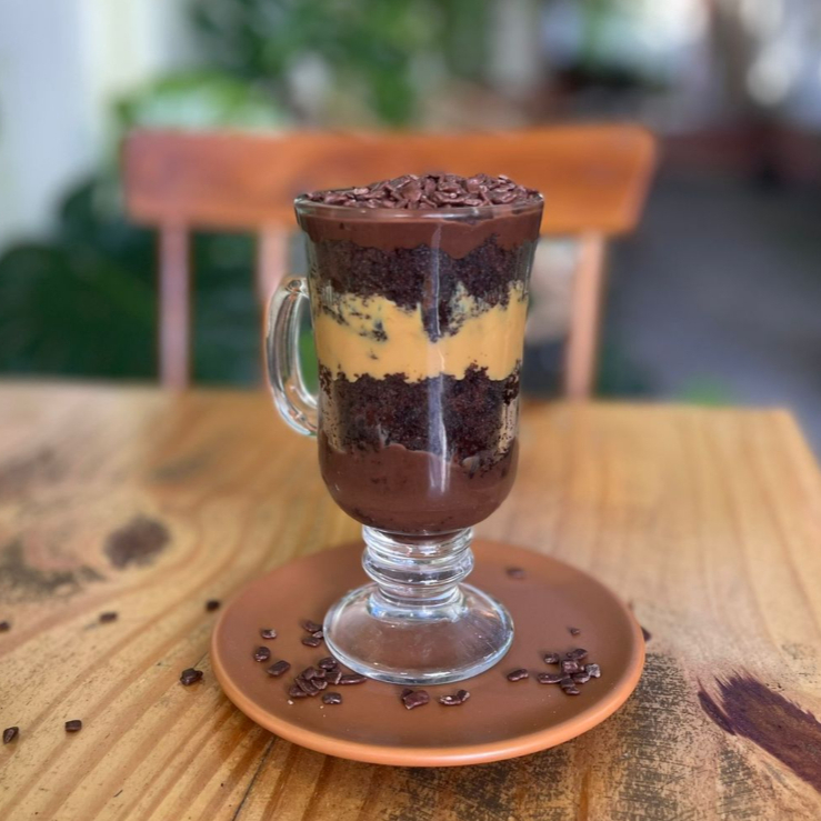 Bolo de caneca irresistível, servido com ganache de chocolate e brigadeiro de ninho cremoso.