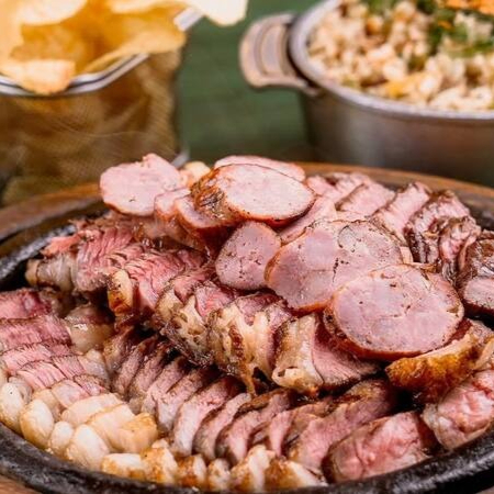 Chorizo, capitão de alcatra, bombom de alcatra e linguiça, com arroz carreteiro, chips de batata frita, farofa e vinagrete.