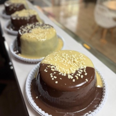 Massa fofinha de chocolate, com uma generosa cobertura de brigadeiro de chocolate ao leite e brigadeiro branco, finalizado com granulé de chocolate branco