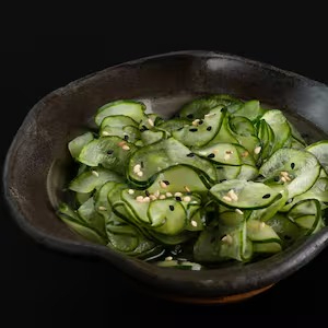 Finíssimas fatias de pepino japonês, em delicado molho agridoce e gergelim
