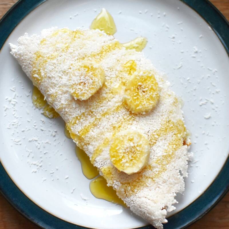 Se você ama combinações que unem sabor, leveza e aquele docinho na medida certa, essa tapioca vai te surpreender! O coco ralado combinado com a banana quentinha cria uma mistura perfeita entre textura e sabor, trazendo um toque tropical e aconchegante em cada mordida. Quer deixar ainda mais especial? A tapioca da foto está com adicional de mel, disponível na seção “Adicionais Extras” do nosso cardápio — um toque final que deixa tudo ainda mais saboroso e simplesmente irresistível! Agora é com você! Monte a sua do seu jeito e peça agora. Experimente essa combinação deliciosa que conquista no primeiro pedaço!