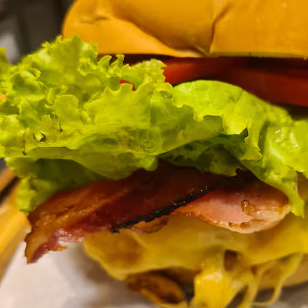 Pão de hambúrguer, hambúrguer, queijo, bacon, alface, tomate e maionese
