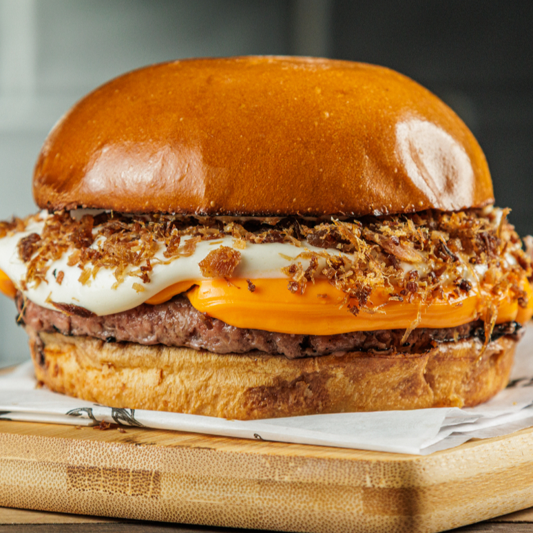 Pão Brioche, Burger 130g,
Queijo Cheddar Cremosão, Farofa de Bacon e Maionese Farini